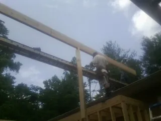 Carpenter setting a ridge beam over a new addition frame — Ice Dam Removal by Roofing Brothers in Knob Lick