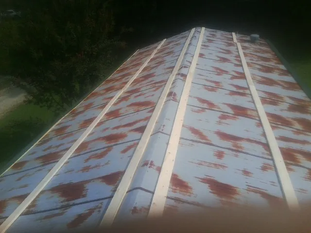 Rusted metal roof panels with new wood purlins before replacement — Storm Damage Roof Repair in Knob Lick by Roofing Brothers