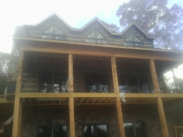 Dormers and porch framing on a large log home under construction — Roof Coating work by our crew in Knob Lick