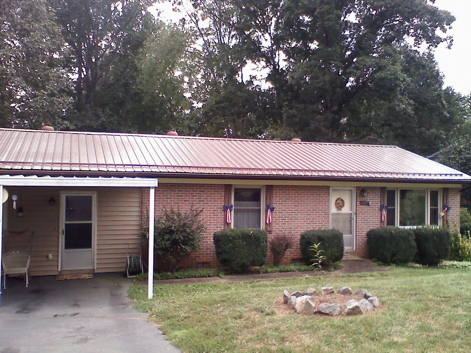 Bronze metal roof and carport on a brick ranch home — Roof Repair work by our crew in Knob Lick